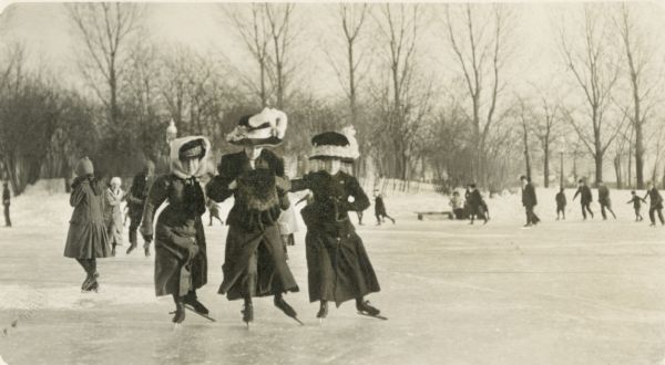 Women in fashionable hats ice skate in Milwaukee