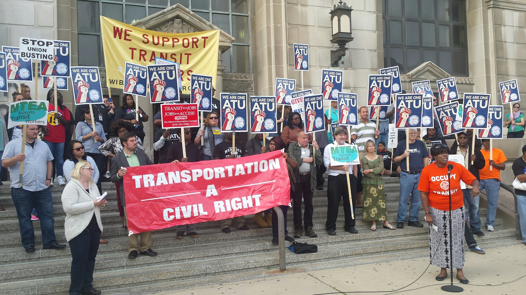 Members of the Milwaukee County bus drivers union and their supporters rally outside the Milwaukee County Courthouse.
