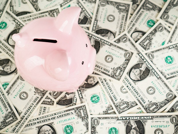 Image of piggy bank atop one dollar bills