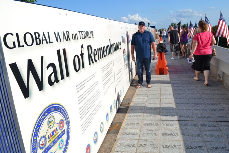 J.R. Nichols stands beside his 120-foot long Wall of Remembrance