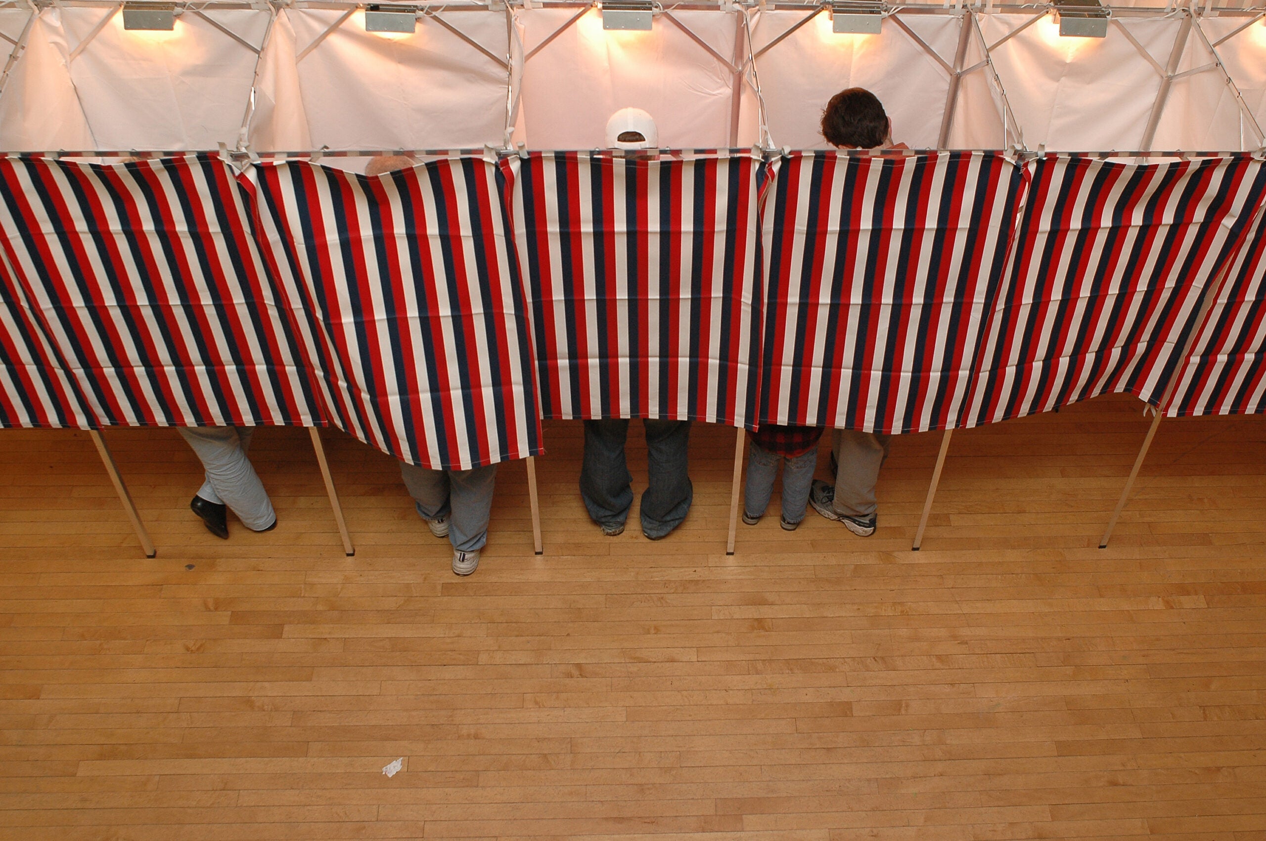 People voting behind a curtain