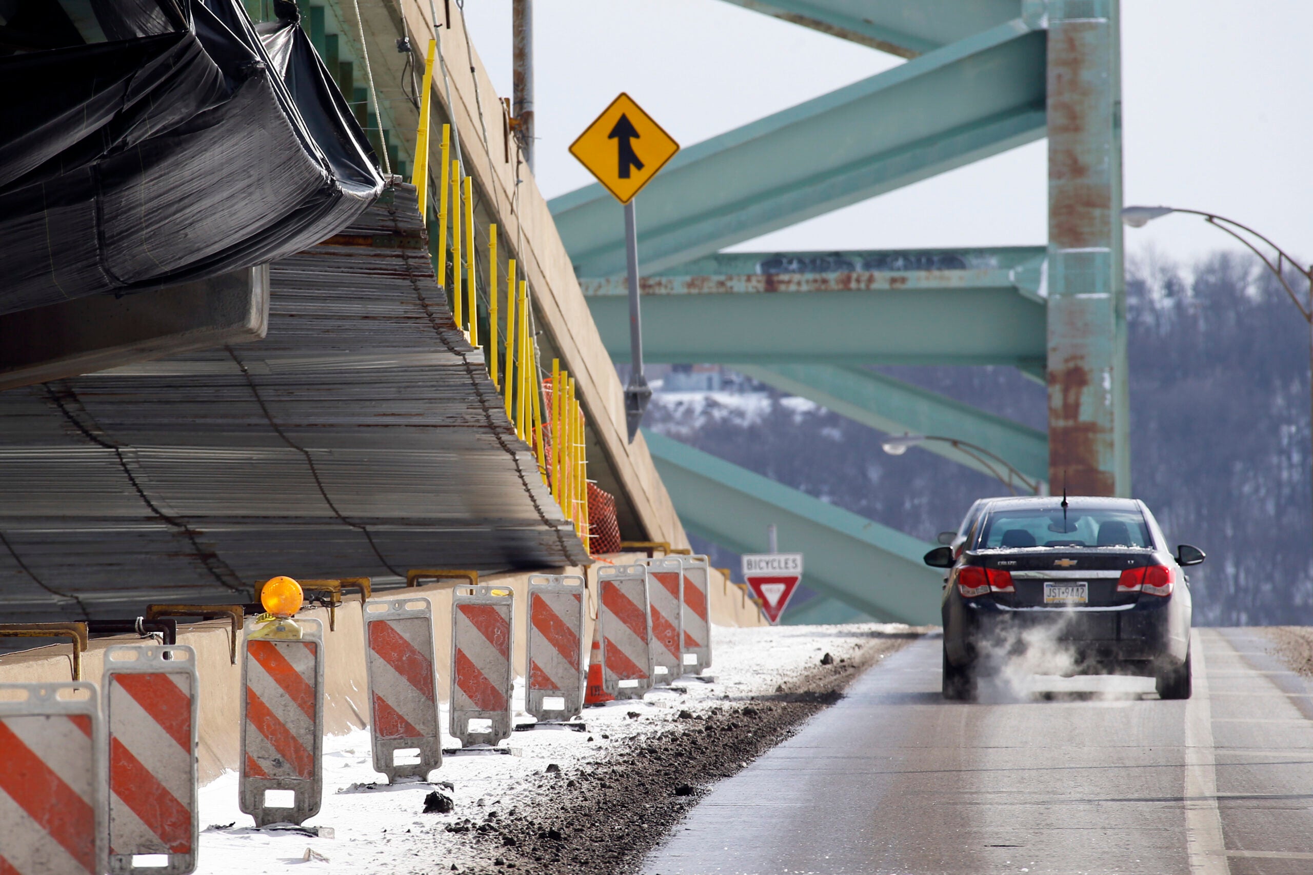 Car driving over bridge with construction