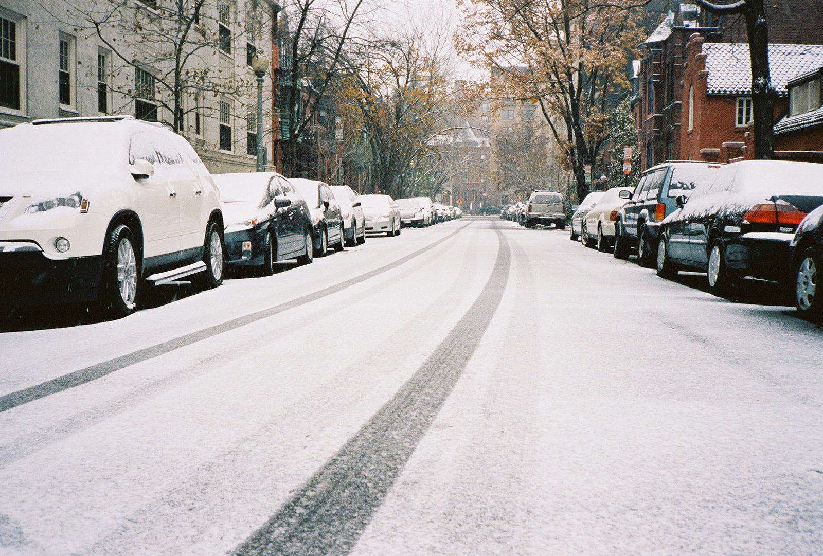 Light dusting of snow covering road and cars