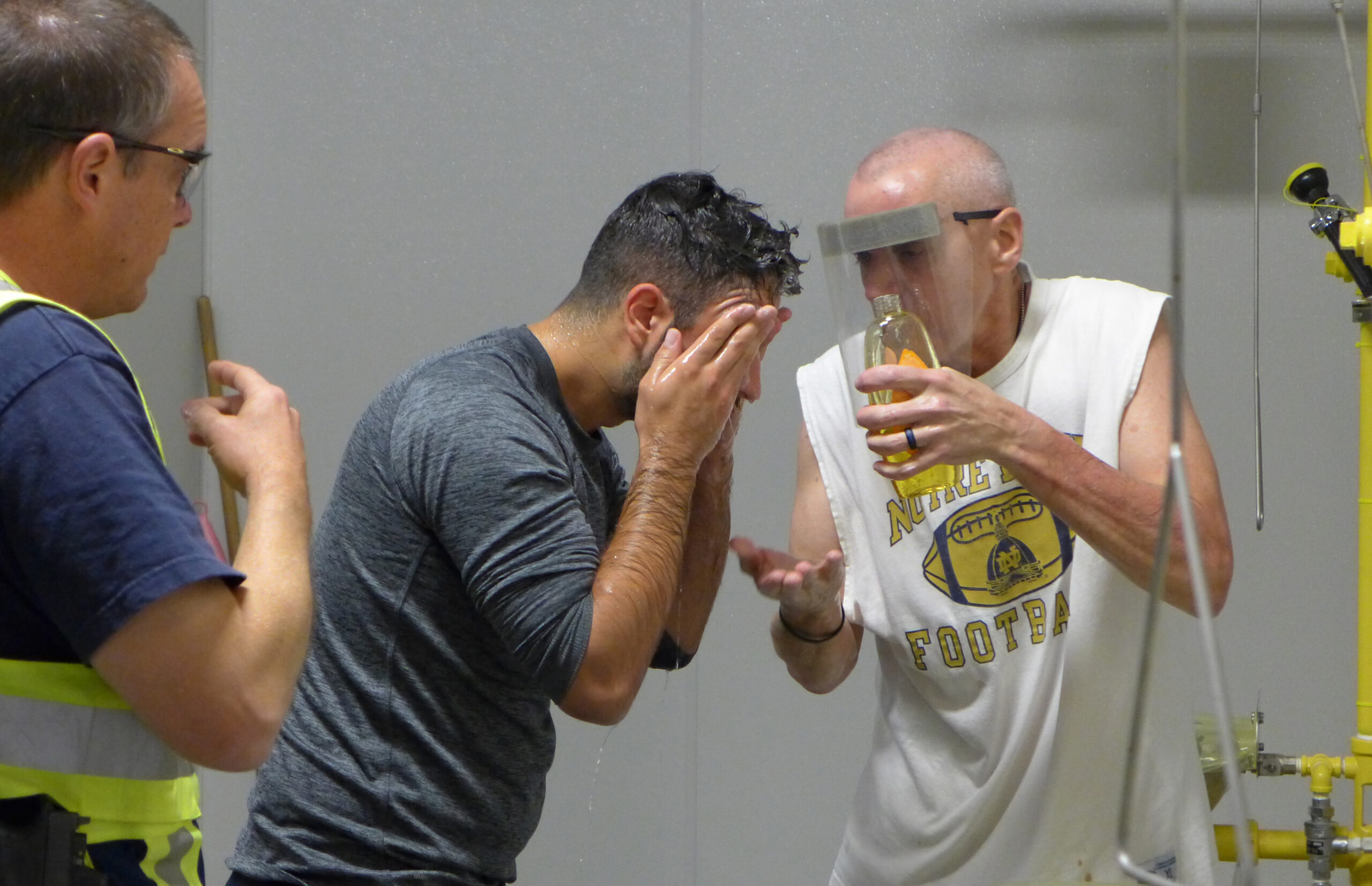Madison Police Chief Mike Koval helps recruit Ercan Dzelil wash his face after being exposed to pepper spray at the Madison Police Training Center.