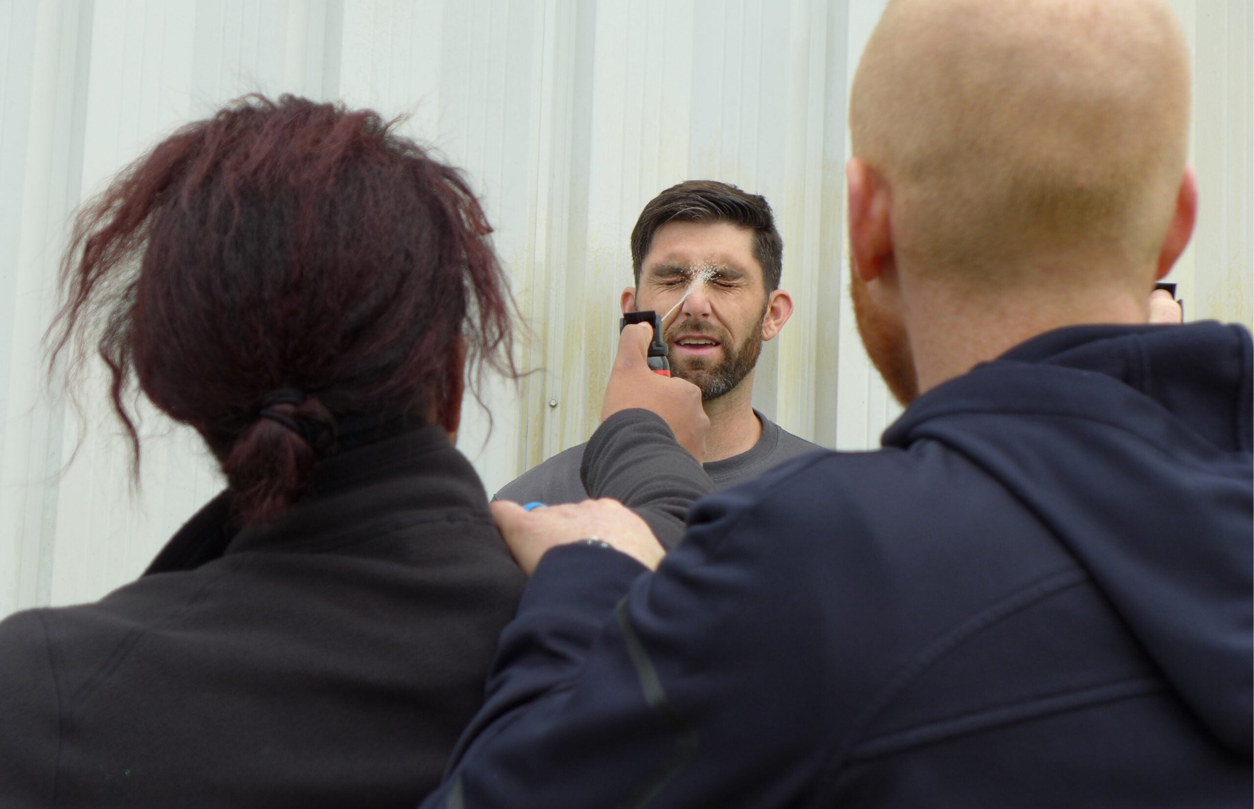 Recruit Justin Cumley is sprayed in the face with pepper spray as part of a training exercise.