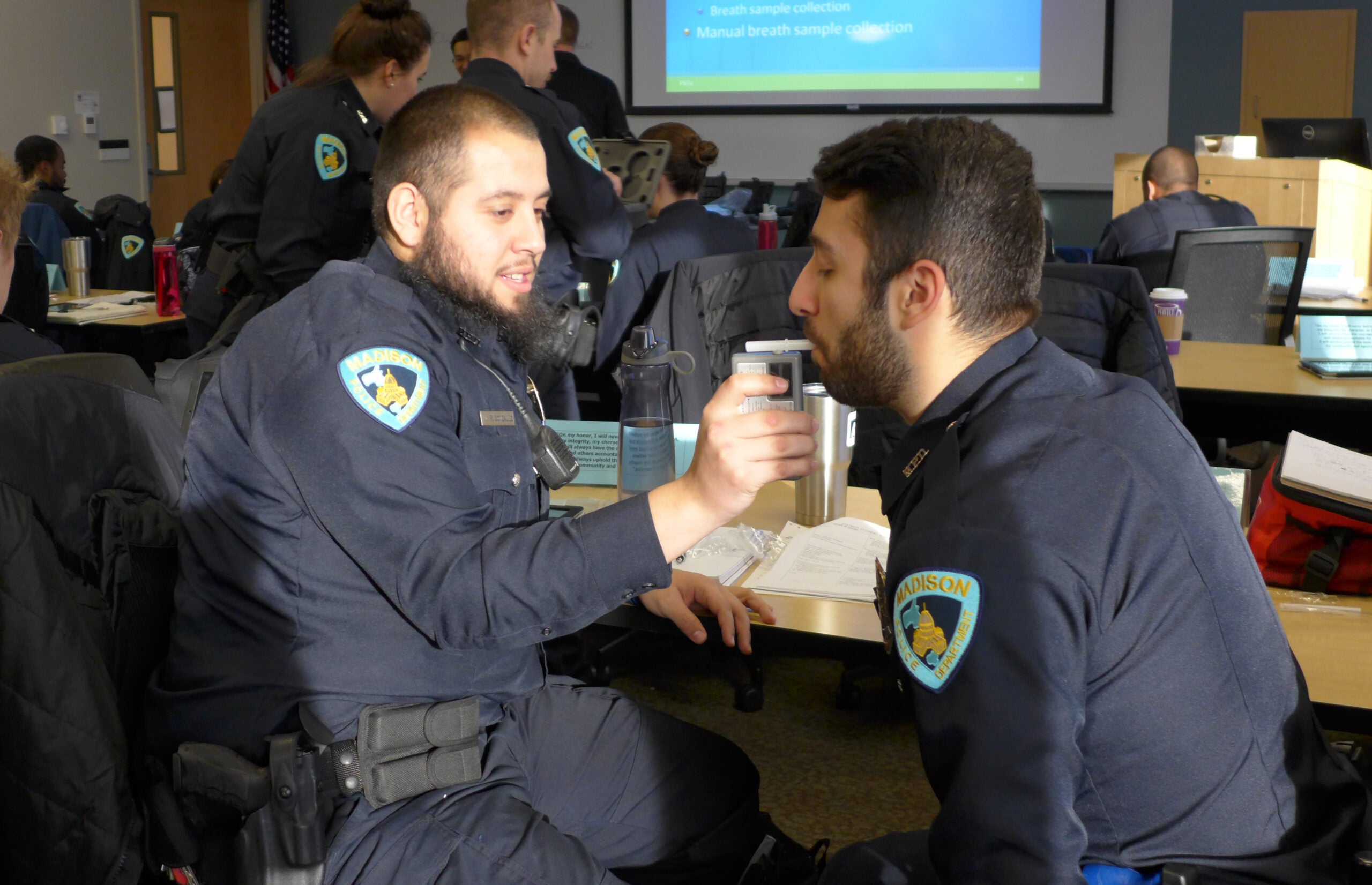 Recruits Ruben Gonzalez and Ercan Dzelil practice using a breathalyzer.