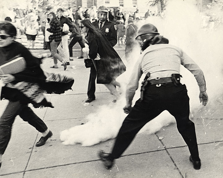 Students flee from police officers spreading tear gas outside the Commerce Building (now Ingraham Hall) at a protest against Dow Chemical, October 18, 1967.