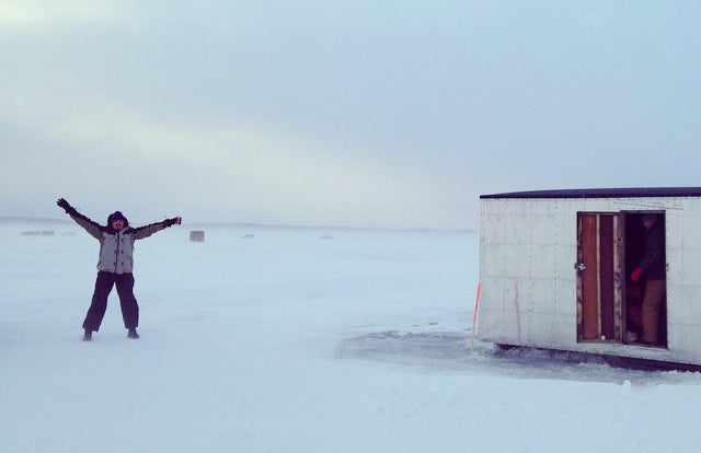 fisher on lake with ice shanty