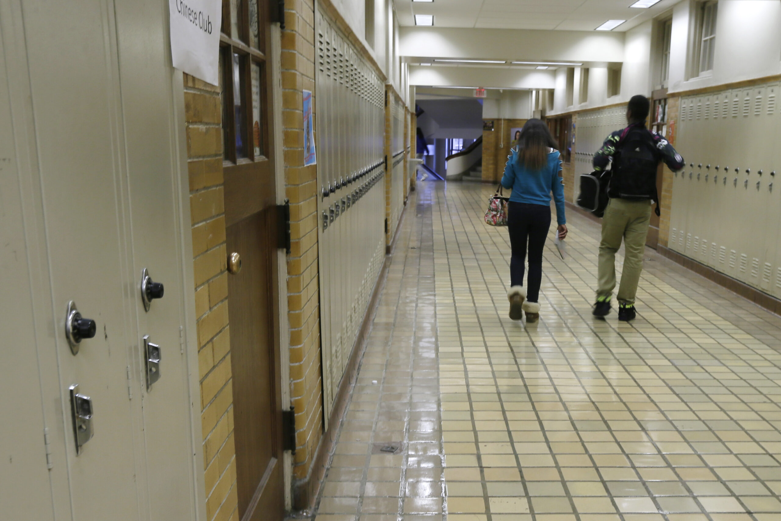 two students walk in a hallway