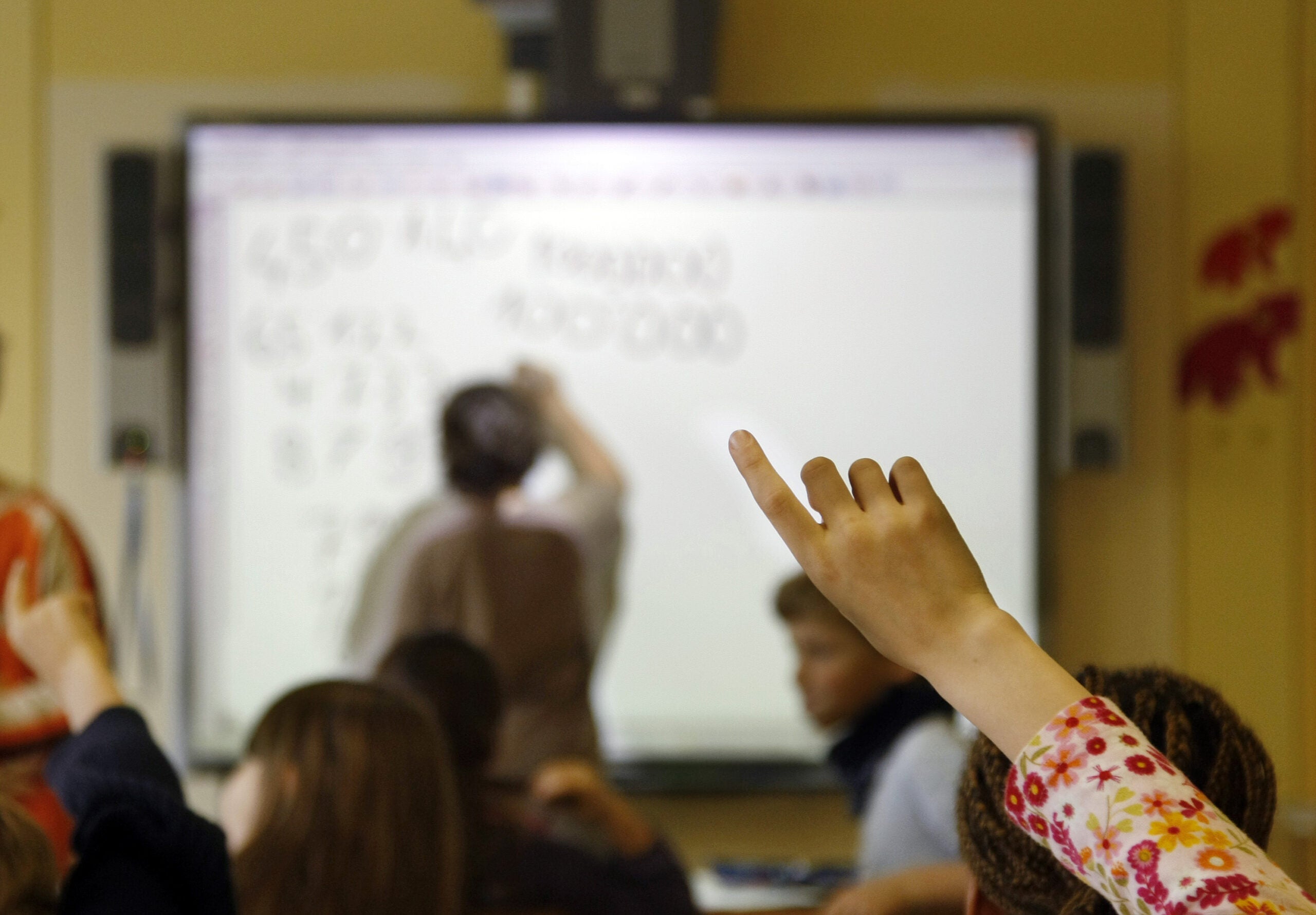 Student raising hand in classroom