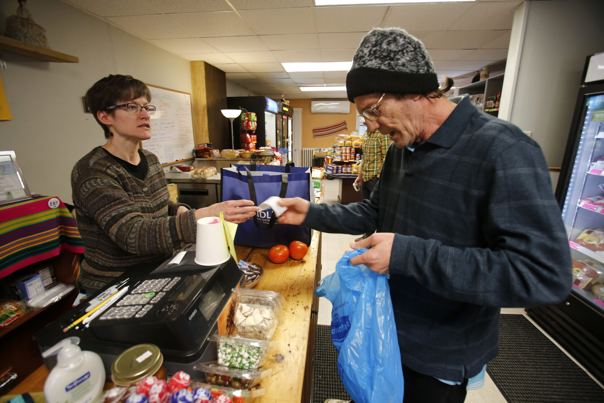 Dianne Shenk, left, helping customer Terry Warby 