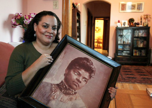 In this Dec. 2, 2011 file photo, Michelle Duster, great-granddaughter of civil rights pioneer Ida B. Wells who led a crusade against lynching during the early 20th century, holds a portrait of Wells in her home in Chicago's South Side.