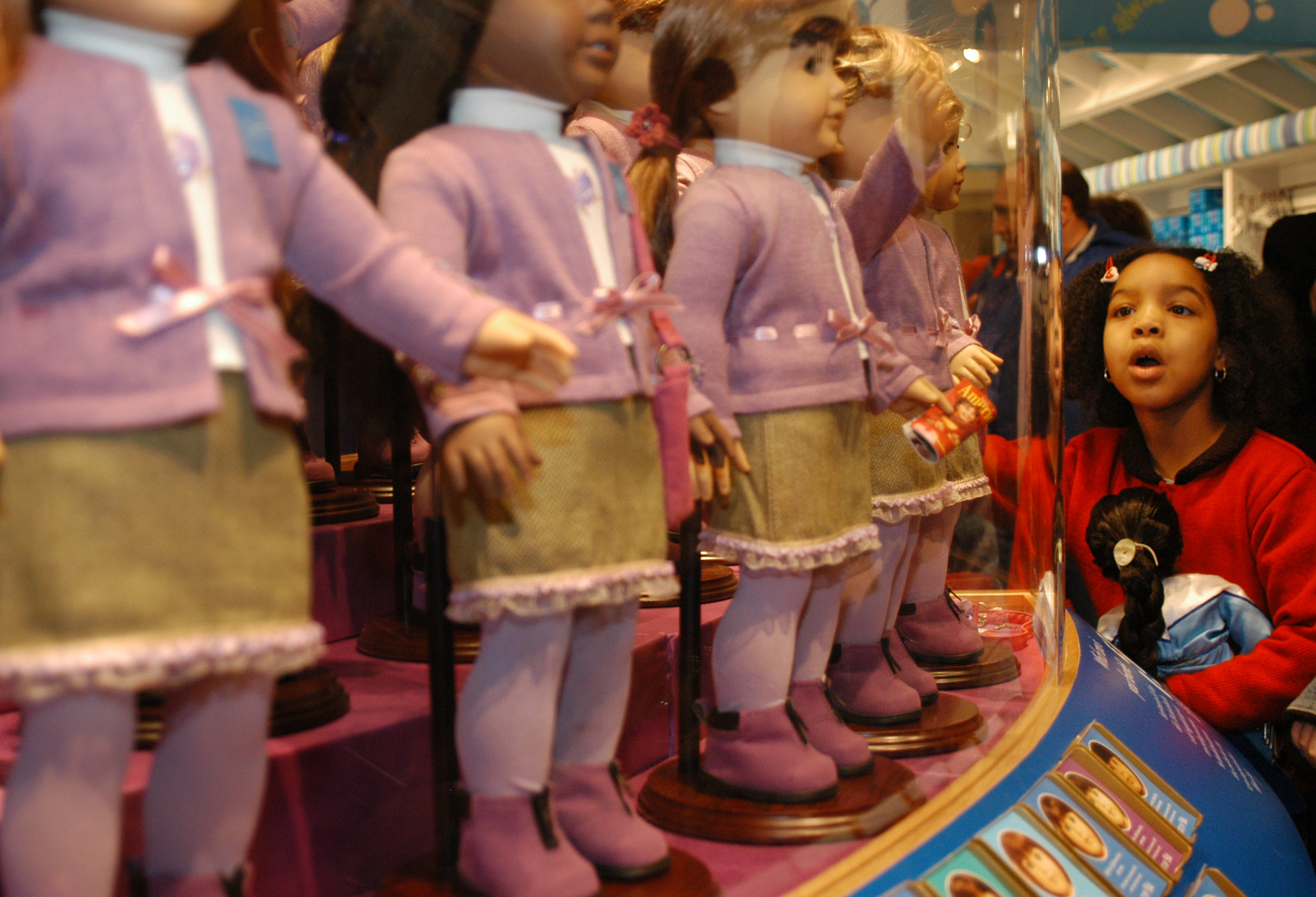 Girl looking at American Girl dolls