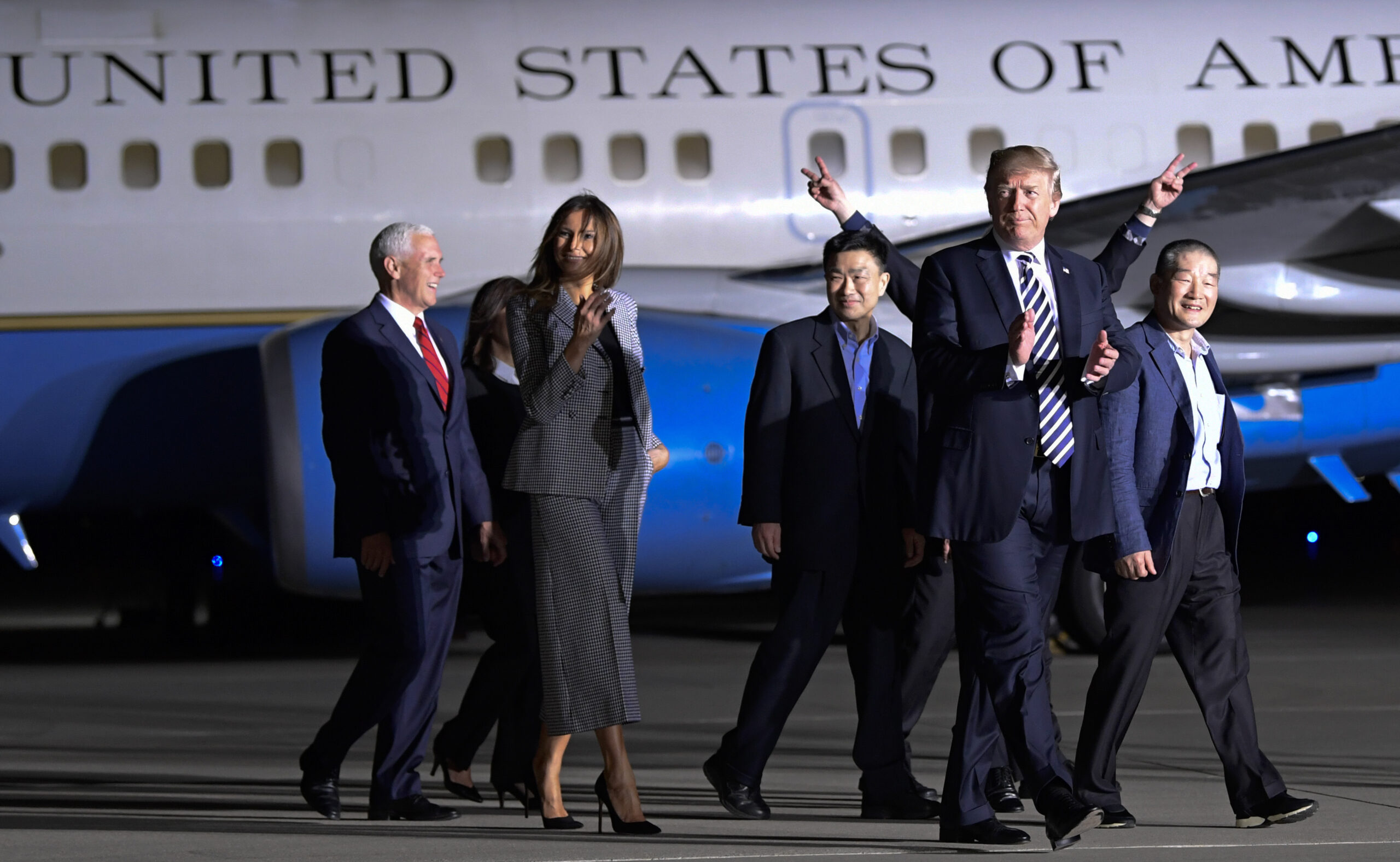 President Donald Trump walks with Tony Kim, third right, Kim Dong Chul, right, and Kim Hak Song, behind Trump, the three Americans detained in North Korea for more than a year
