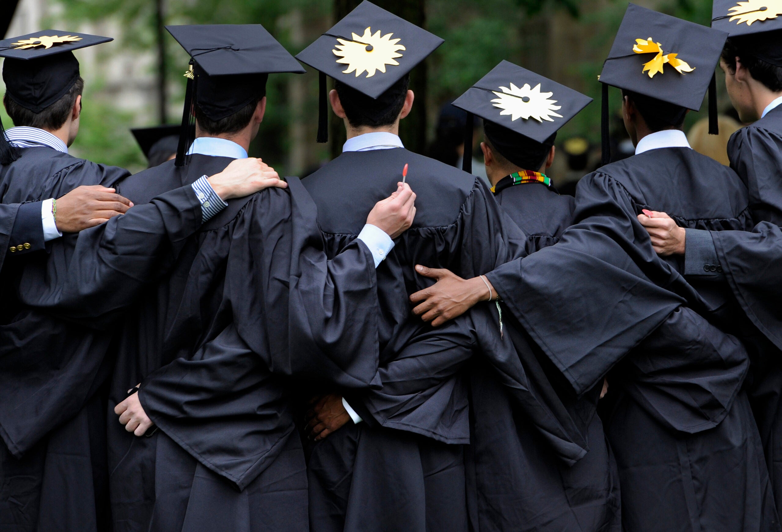 graduates pose for photographs during commencement