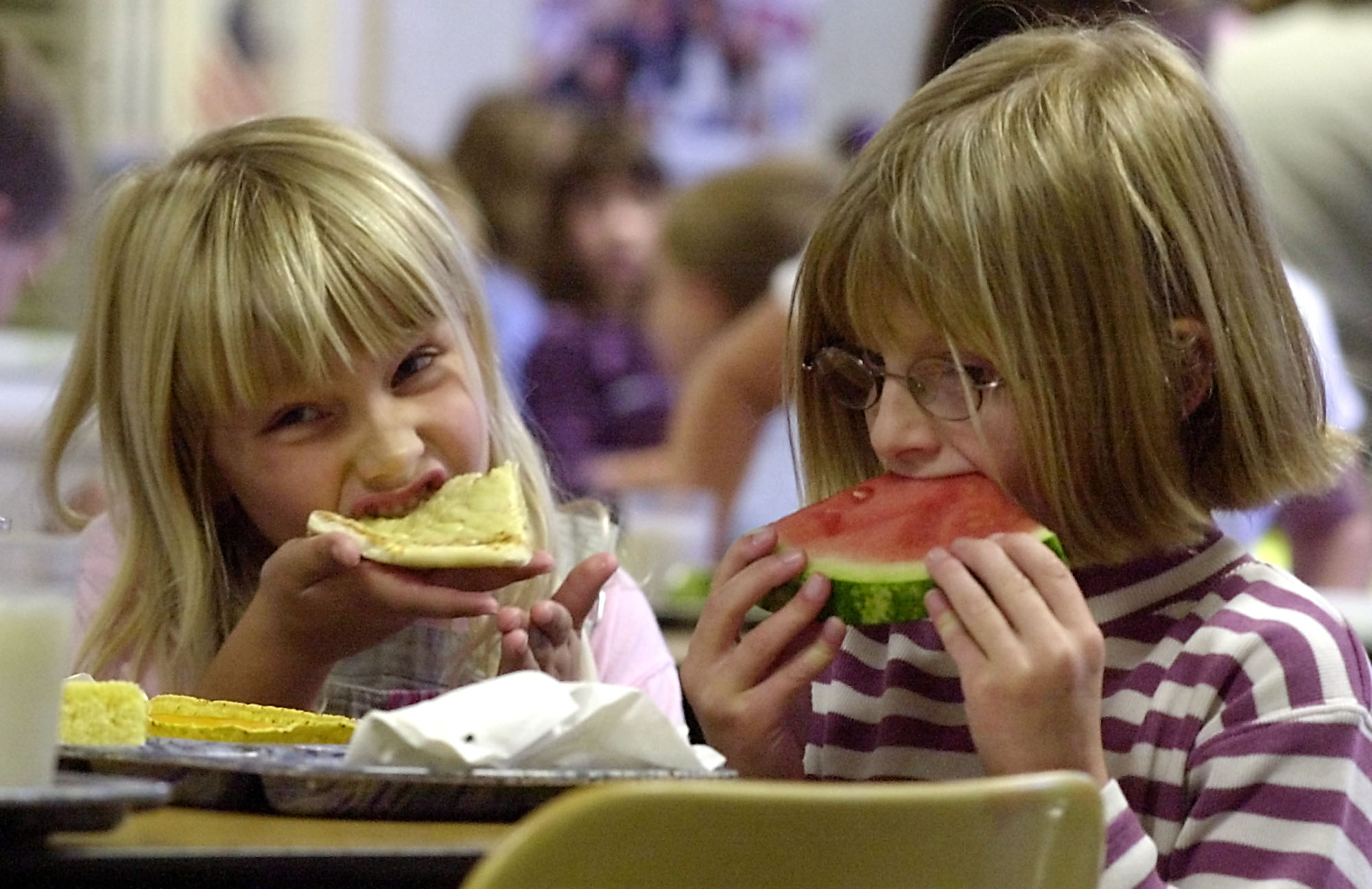 Kayla Reynolds, 6, left, and Kirsten Desorda, 7, eat lunch at school