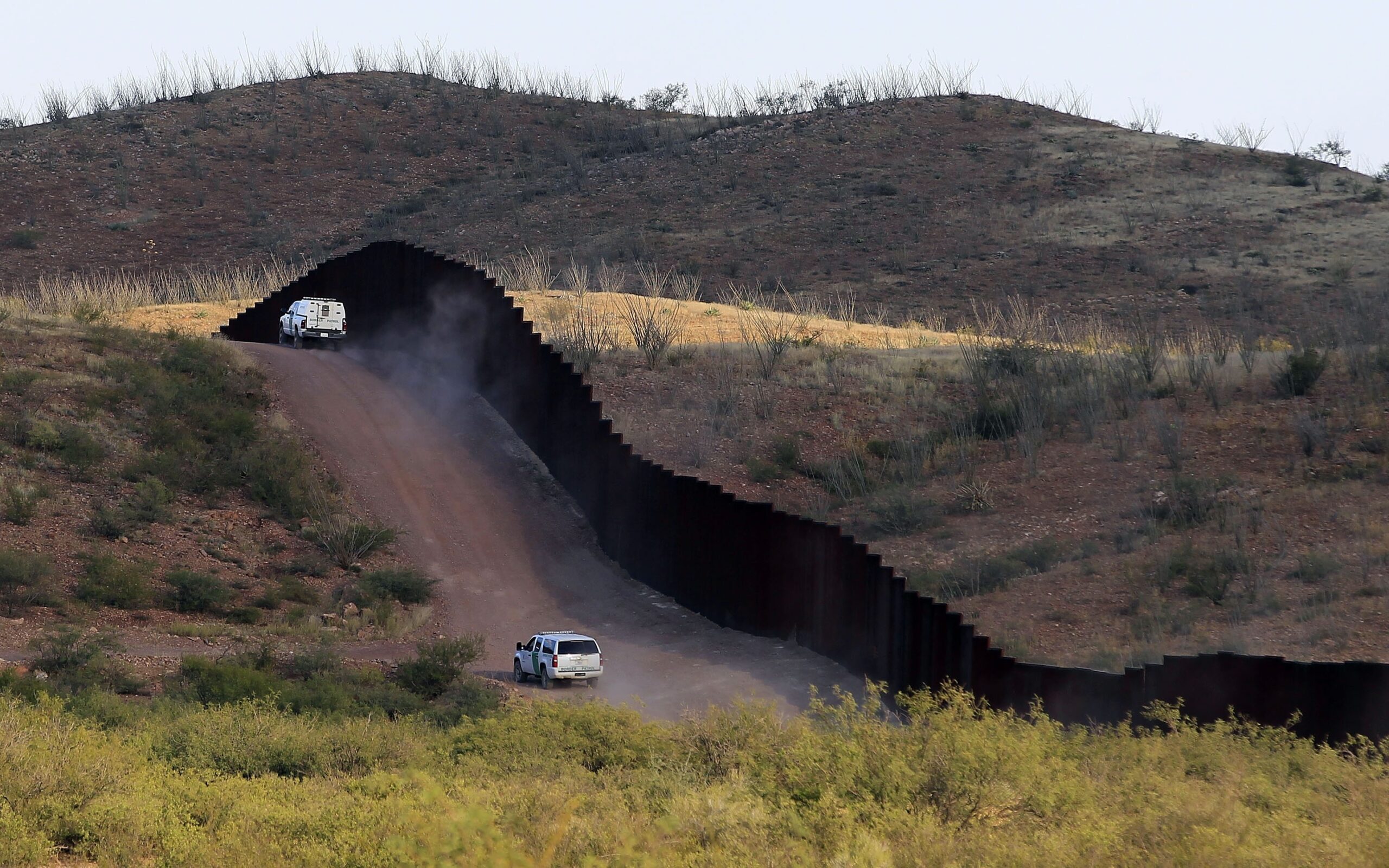 U.S. Border Patrol agents patrol the border fence in Naco, Ariz