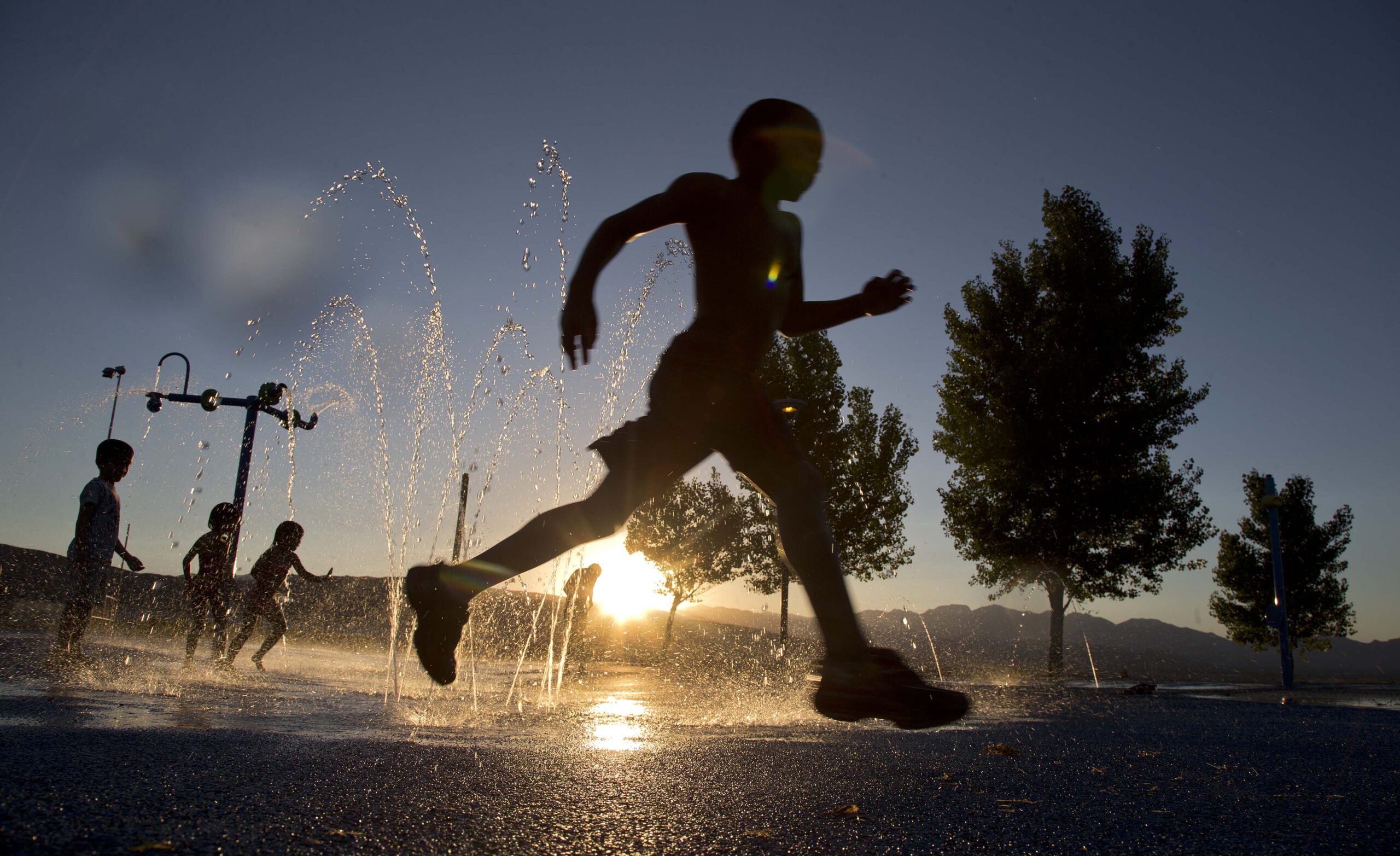 child running through water fountain