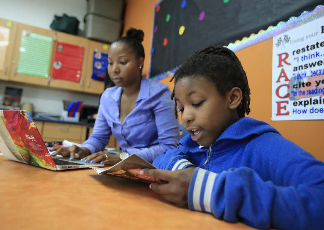 student reading with teacher