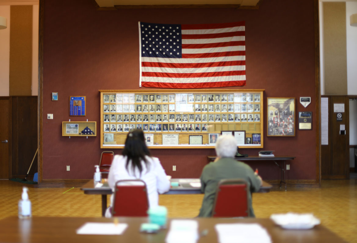 Julie Routhieaux, administrative specialist for the village of Little Chute, Wisconsin, left, and Patti Seeman, an election inspector, help out with voting at the village hall