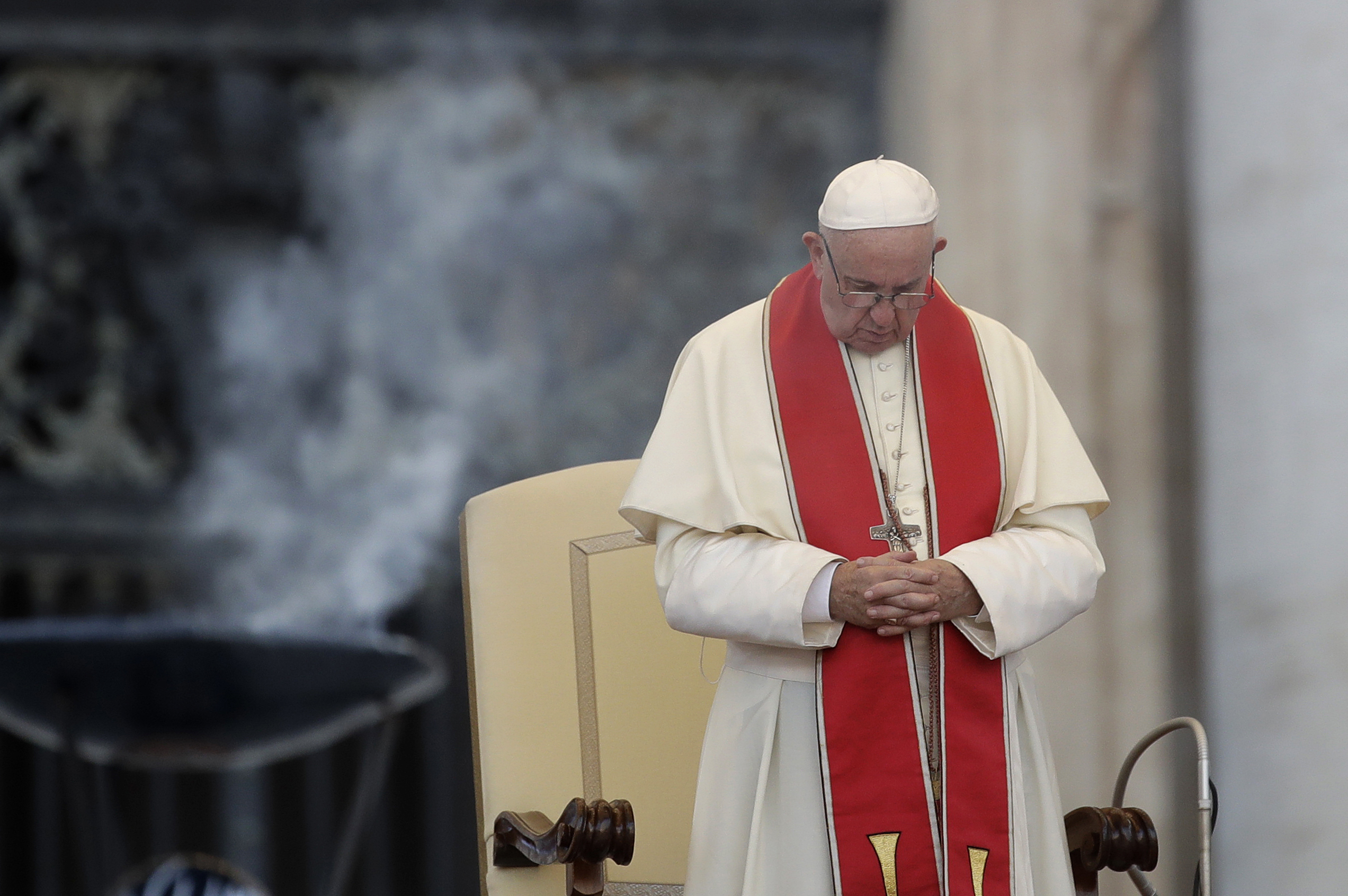 Pope Francis prays during an audience in St. Peter's square at the Vatican