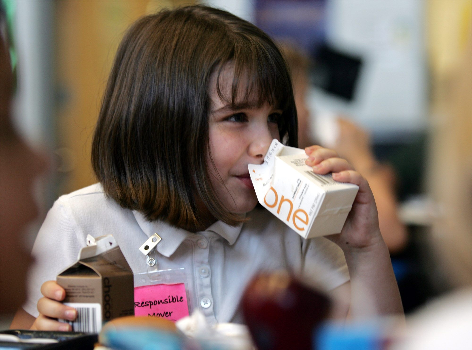 child drinks from containers of one percent milk