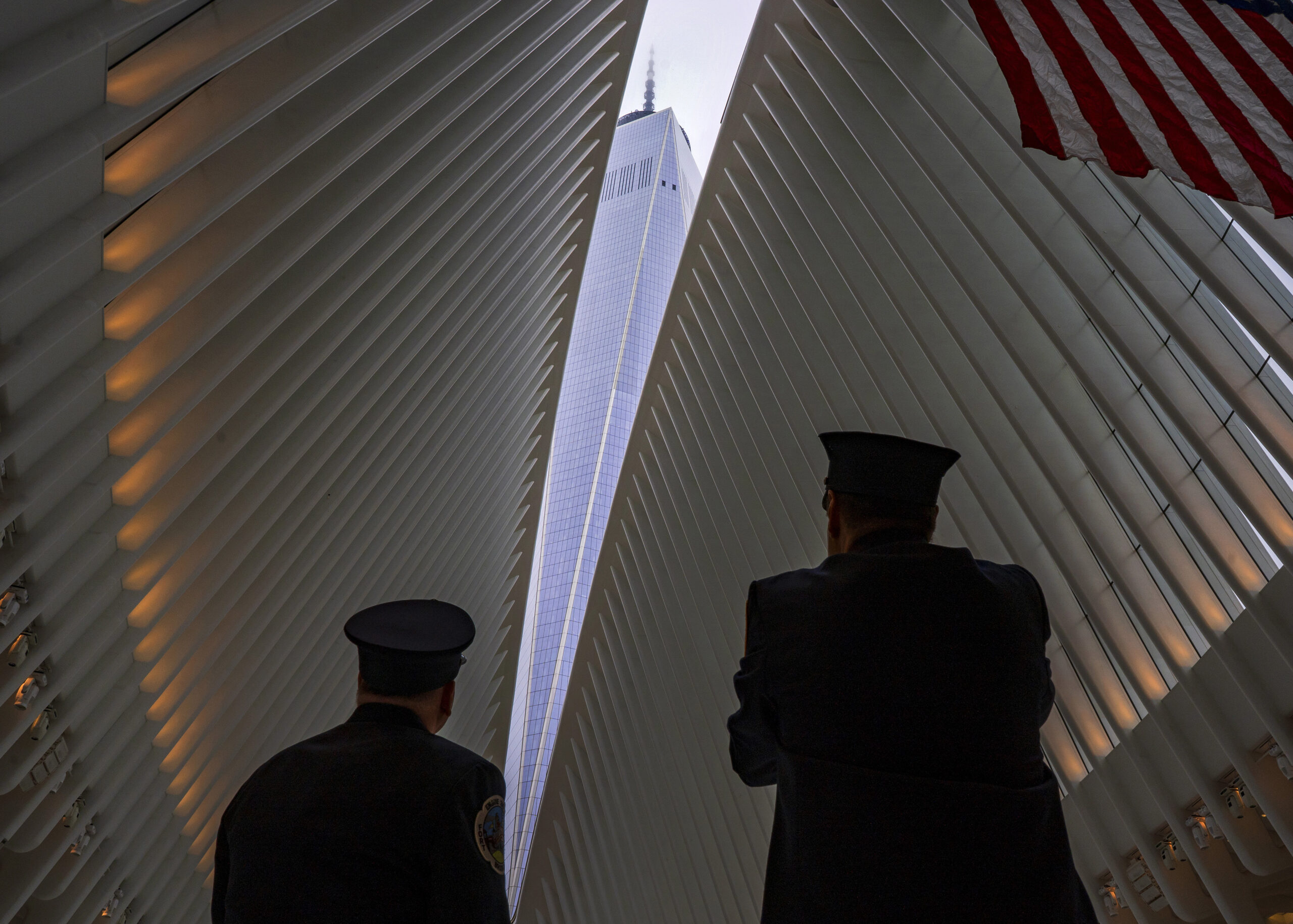 Two members of the New York City fire department look towards One World Trade Center