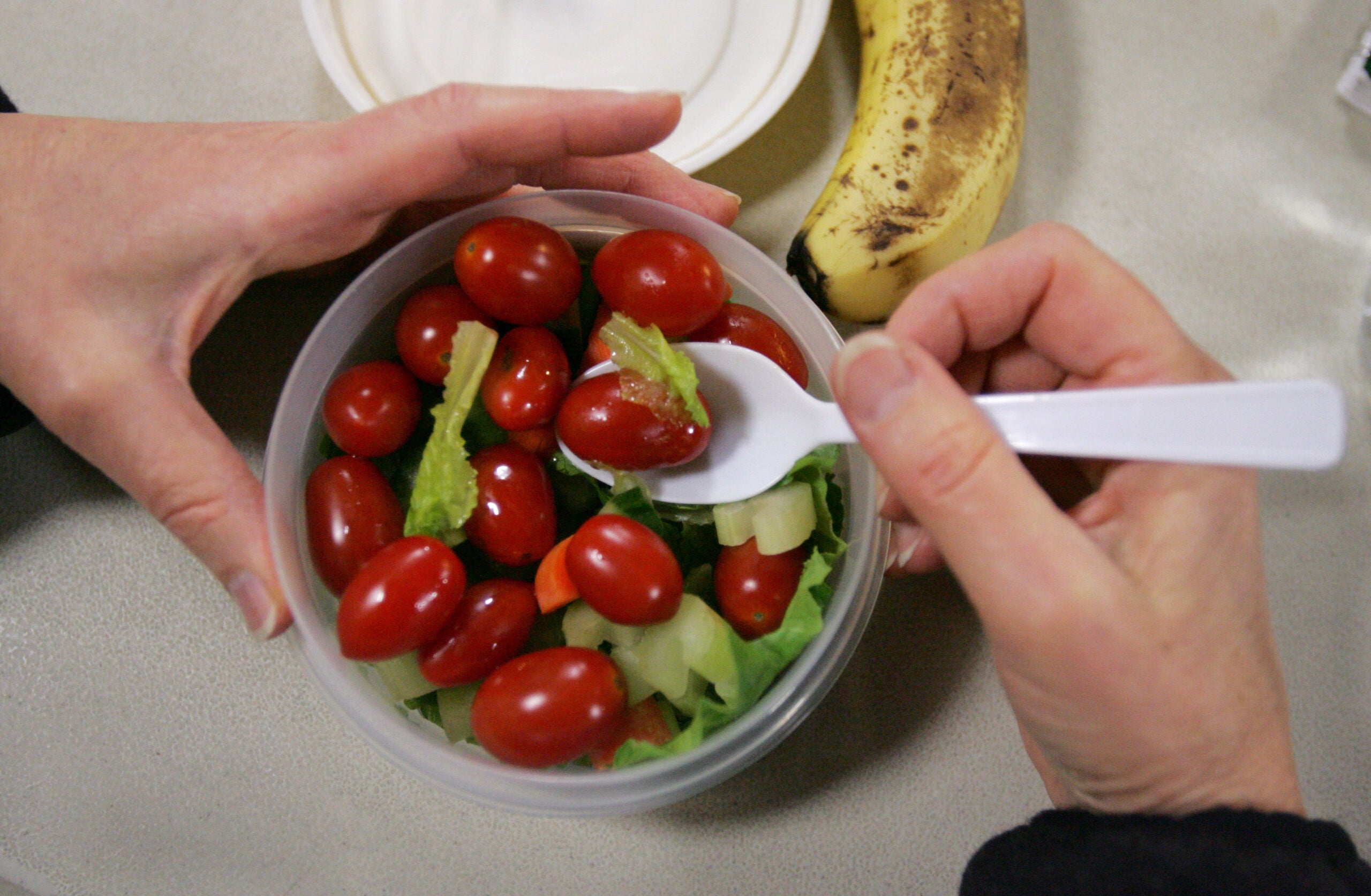 Person eating tomato salad