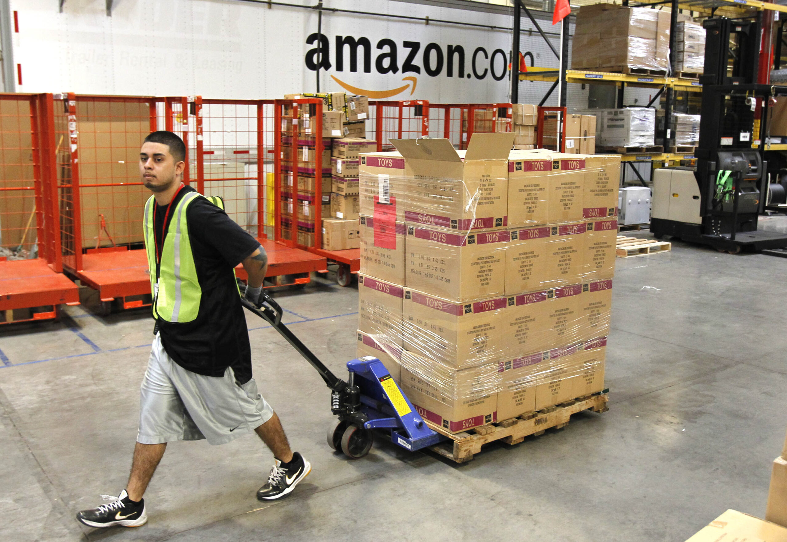 Amazon employee pulling pallet of boxes
