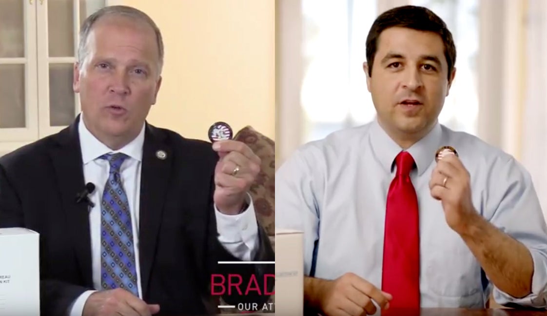 Brad Schimel and Josh Kaul holding coins