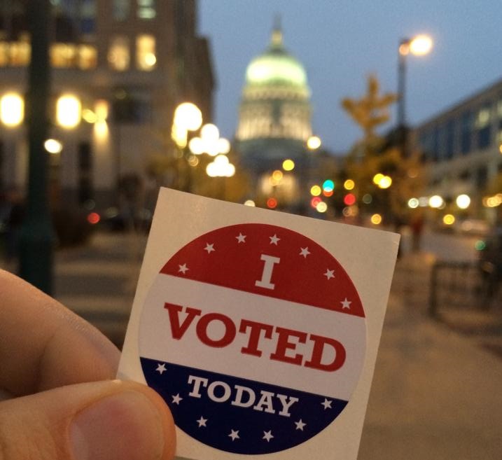 "I Voted Today" sticker held in front of the Wisconsin state capitol