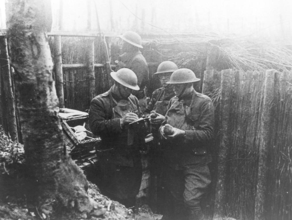 France - Army Reserve Soldiers writing messages for pigeon delivery in the trenches of France, 1918.