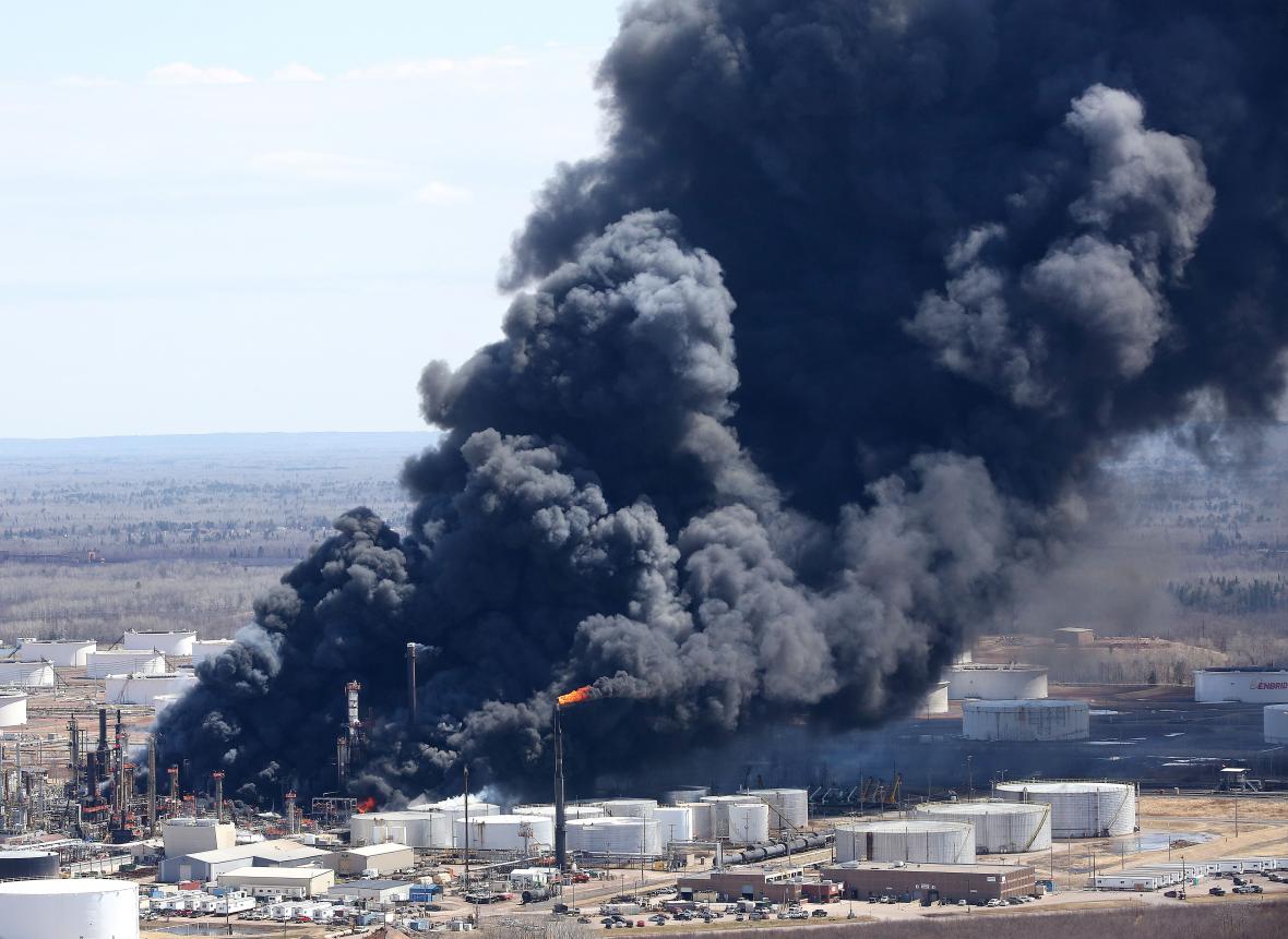 A plume of darks smoke rises from the refinery fire