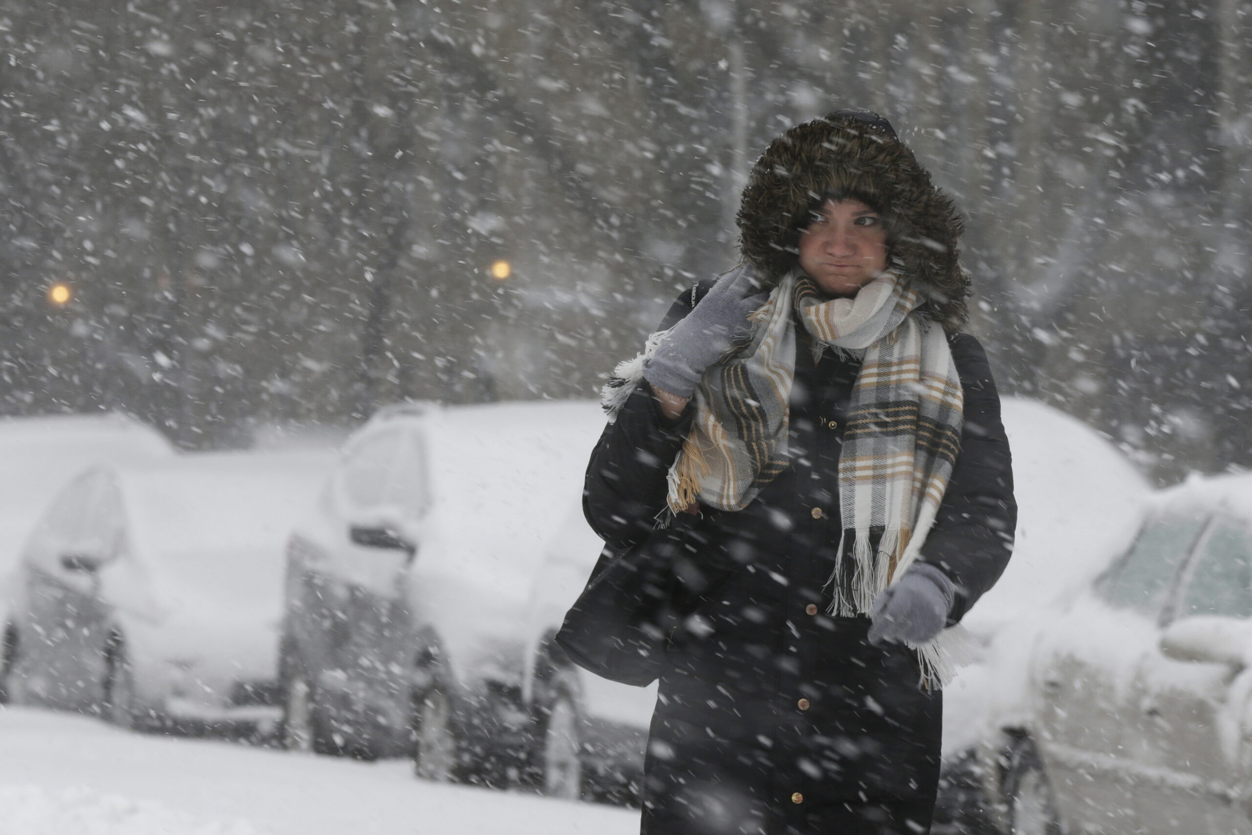 A commuter walks to a bus stop as snow falls this winter