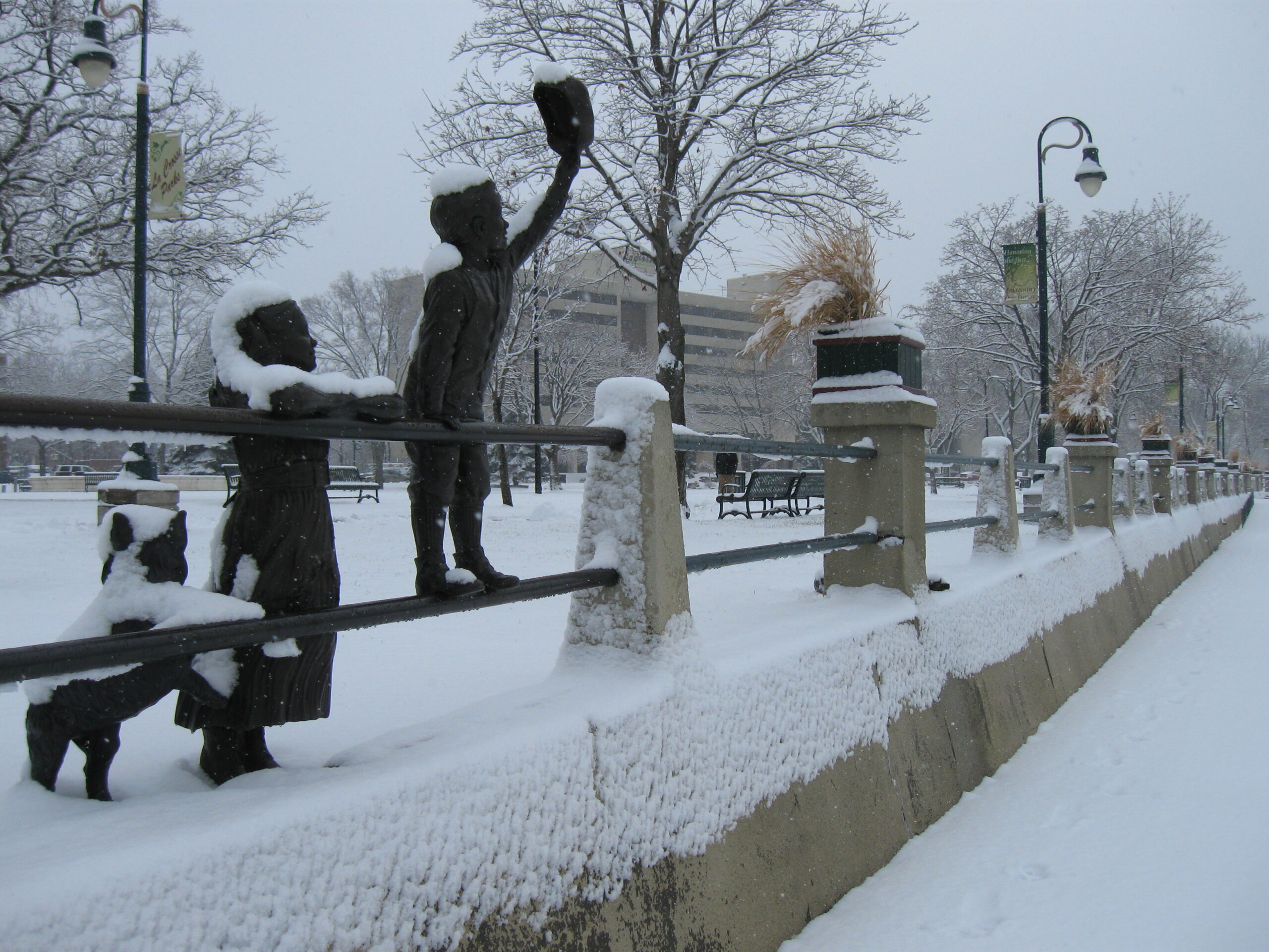 Statues of children greeting riverboats in downtown La Crosse's Riverside Park after snowfall