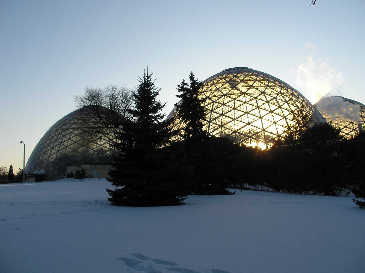 Glass domes with sunlight behind them, in winter landscape