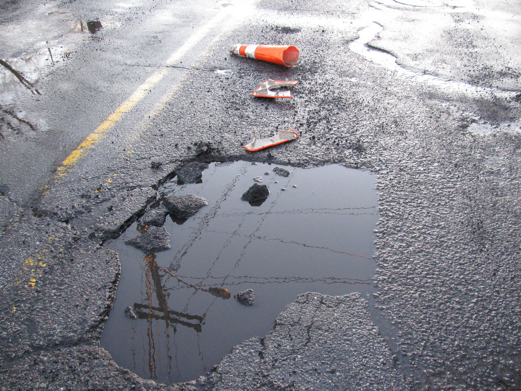 a pothole in the middle of a wet road