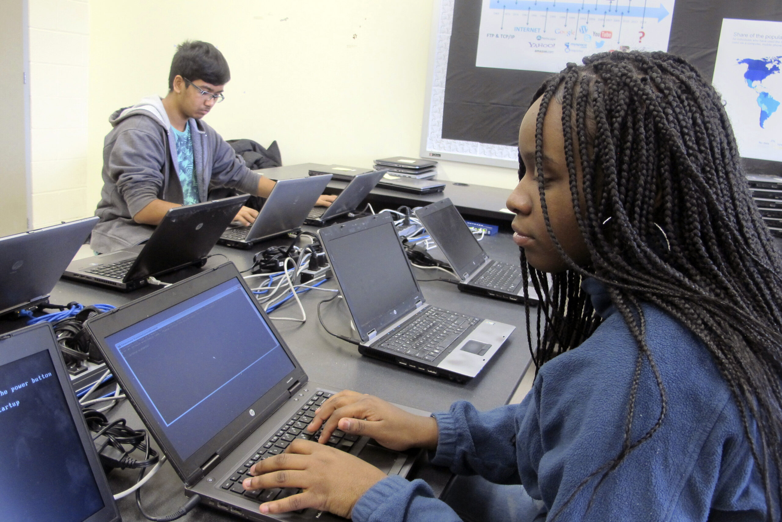students work on re-imaging laptops in a school computer lab