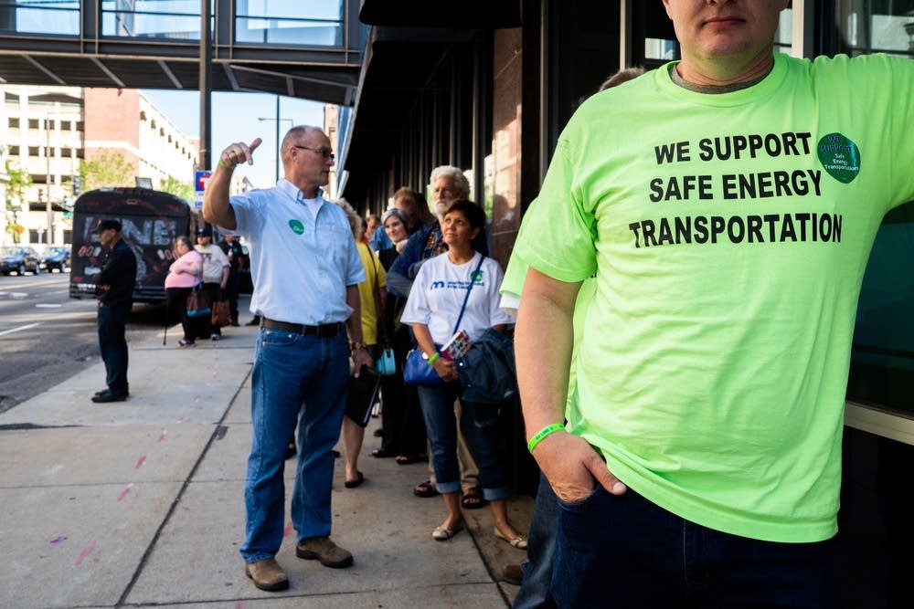 Supporters and opponents of the line 3 oil pipeline line up outside of the Public Utilities Commission