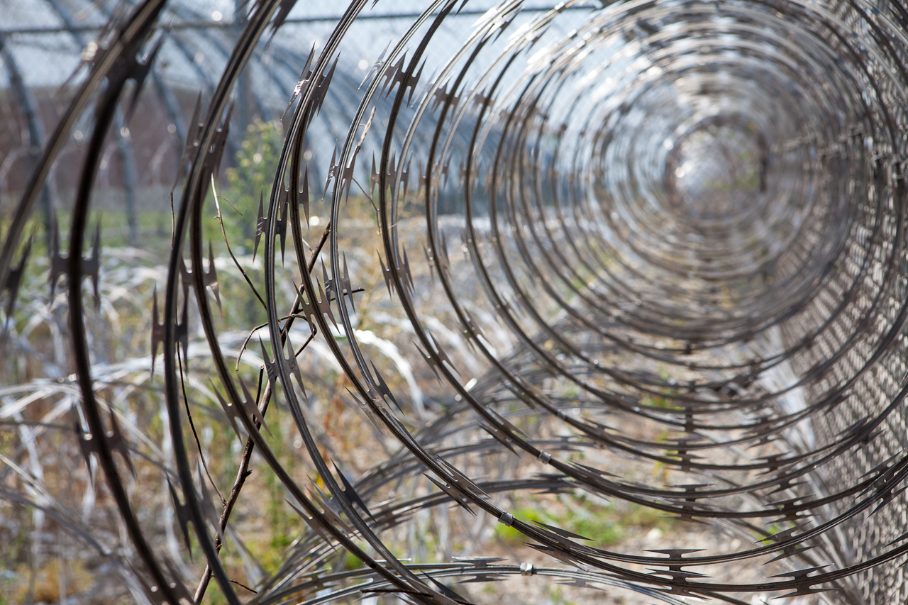 A coil of barbed wire along the walls of a prison
