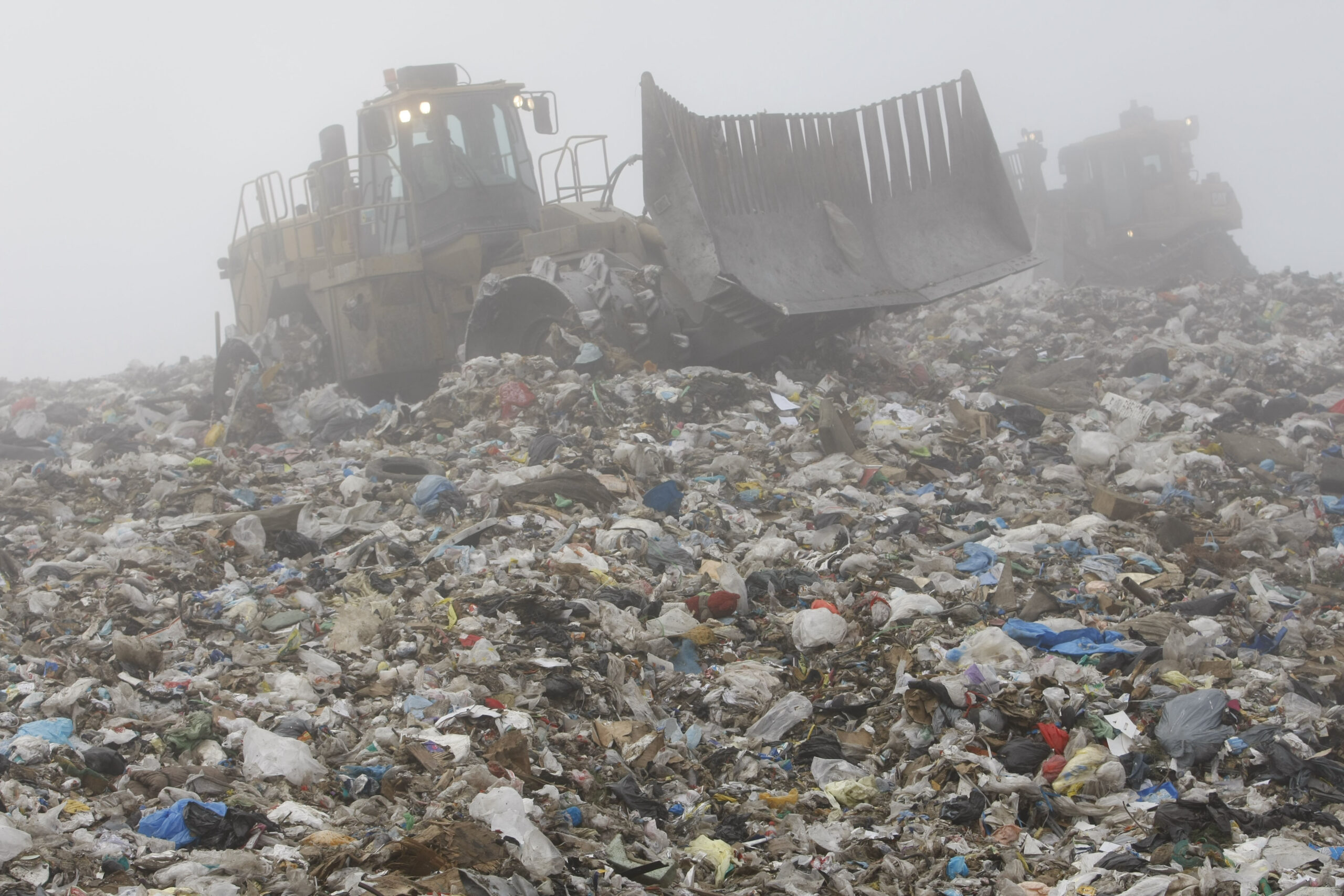 A tractor sorts through waste at a landfill in California