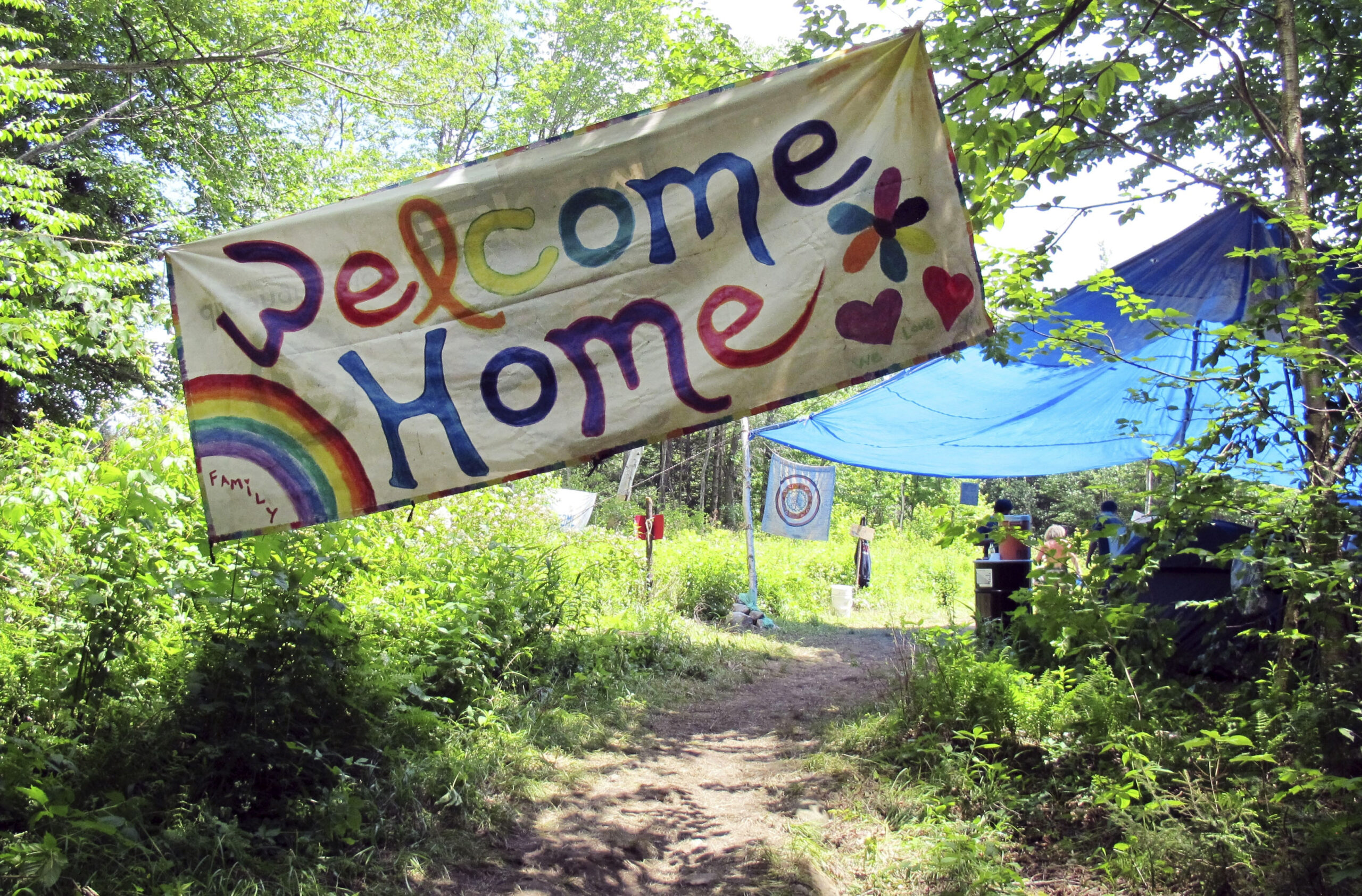a sign welcomes people to the gathering of the Rainbow Family of Living Light