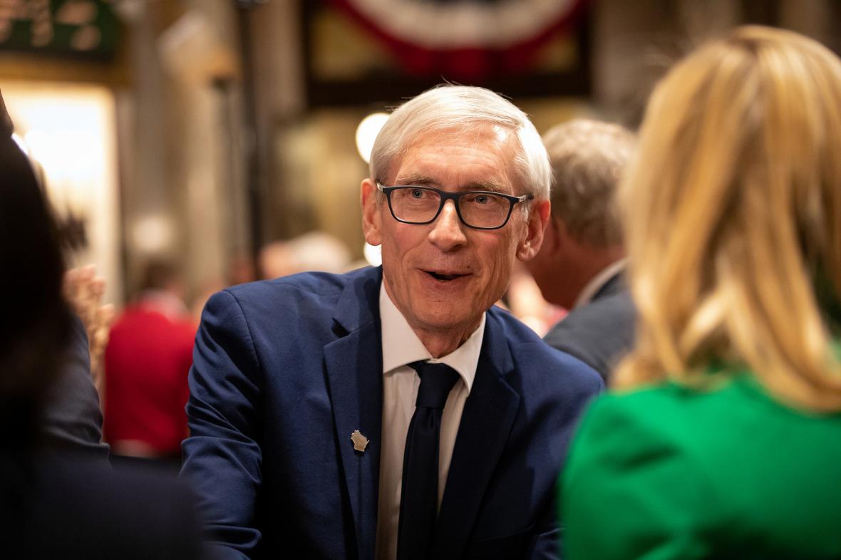 Governor Evers greets two women