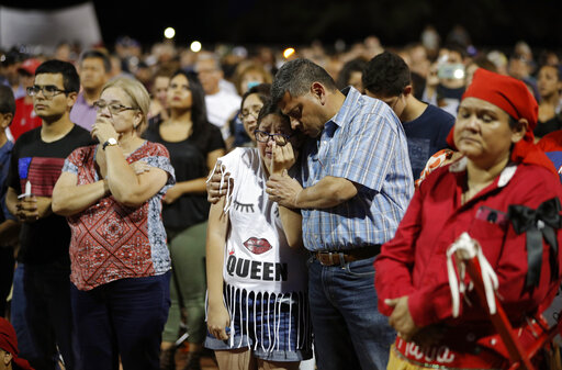 People comfort each other during a vigil for victims of Saturday's mass shooting in El Paso, Texas.