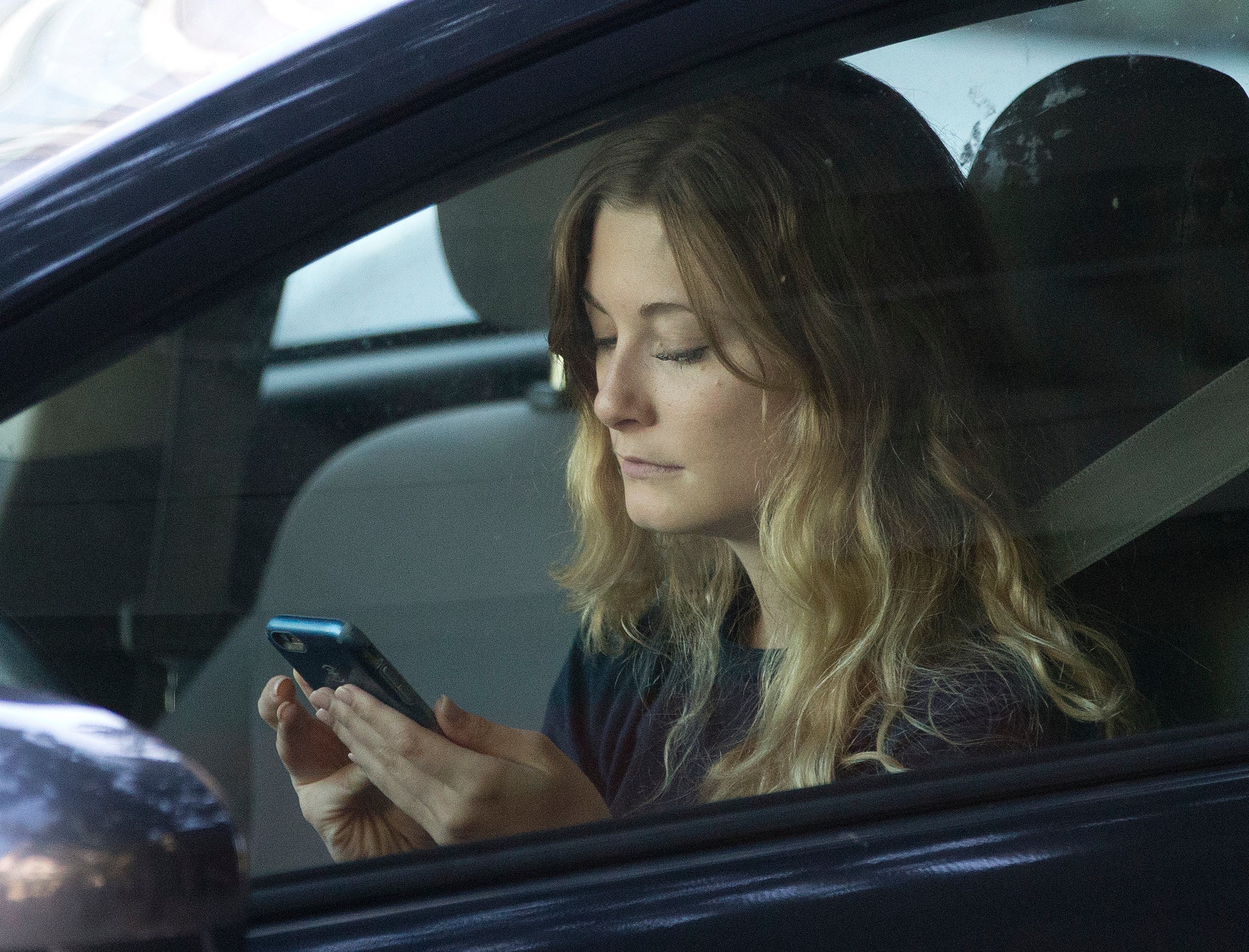 Woman using phone in car