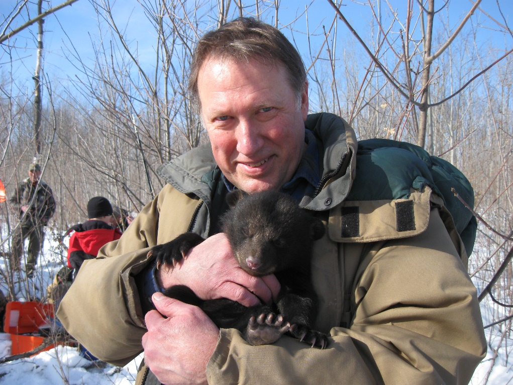 Photo of Glen Moberg holding bear cub