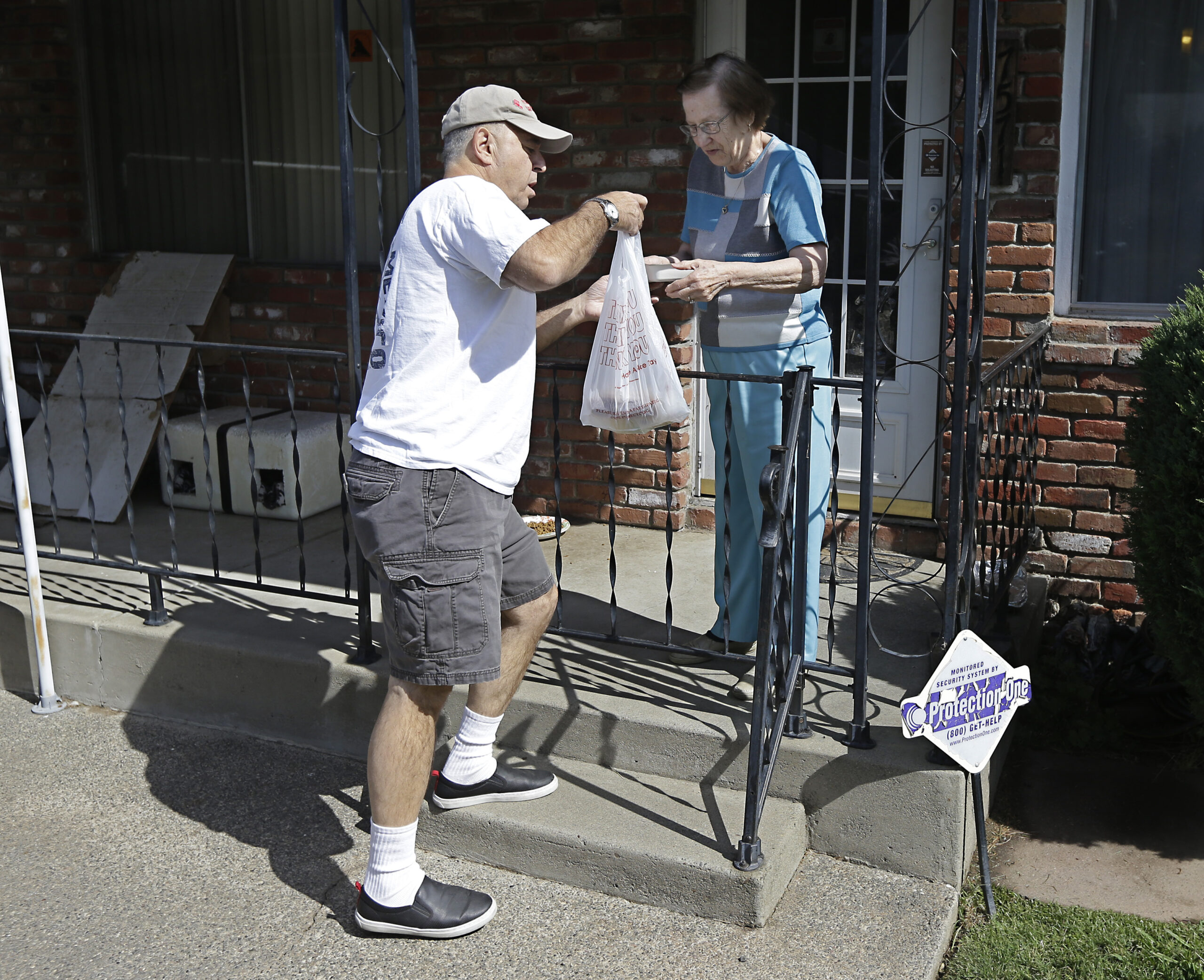 Bob Gill, a volunteer with Meals on Wheels, delivers lunch to Thelma Pense