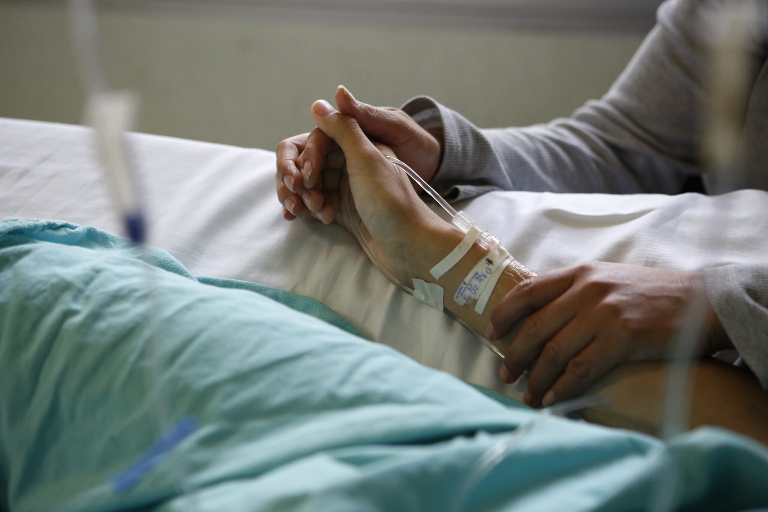 holding hands in hospital bed