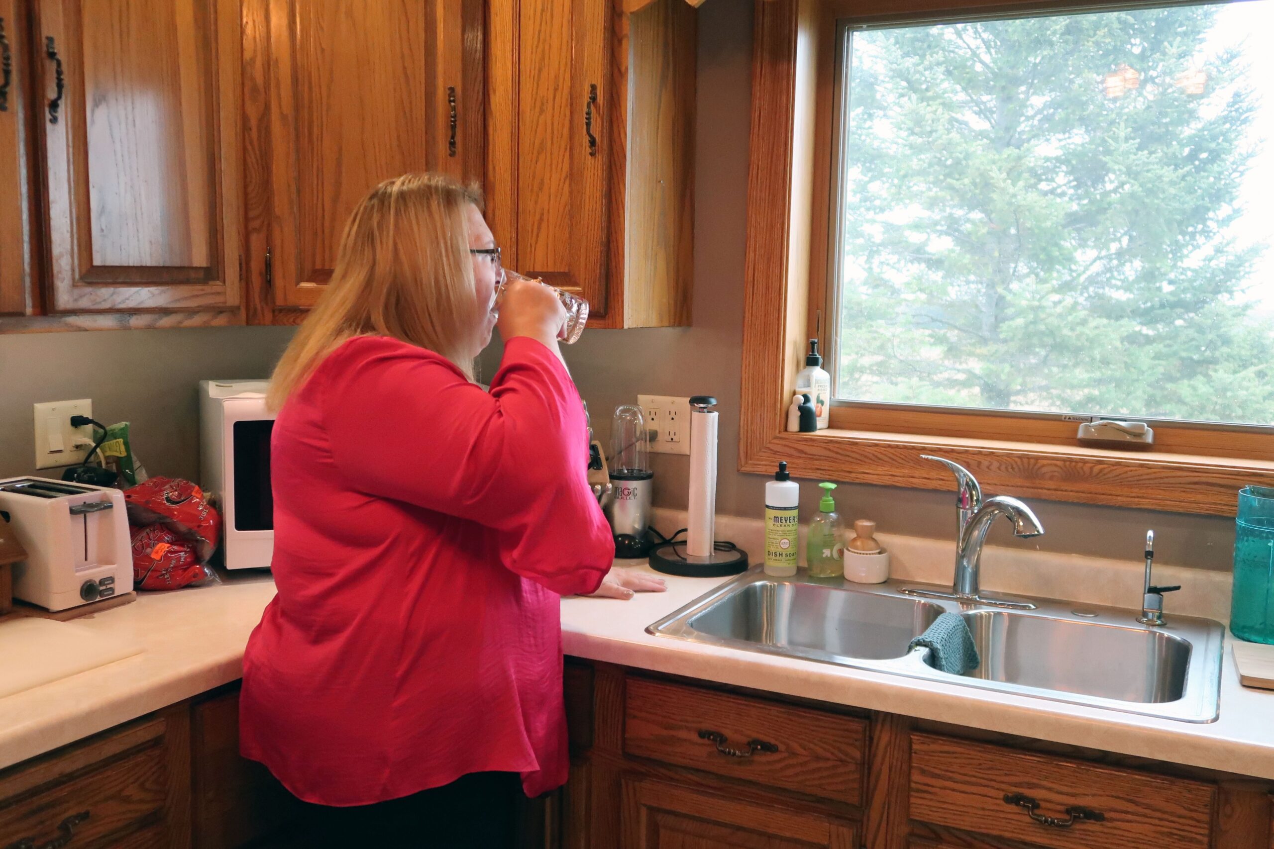 Erika Balza drinks water from a water cooler