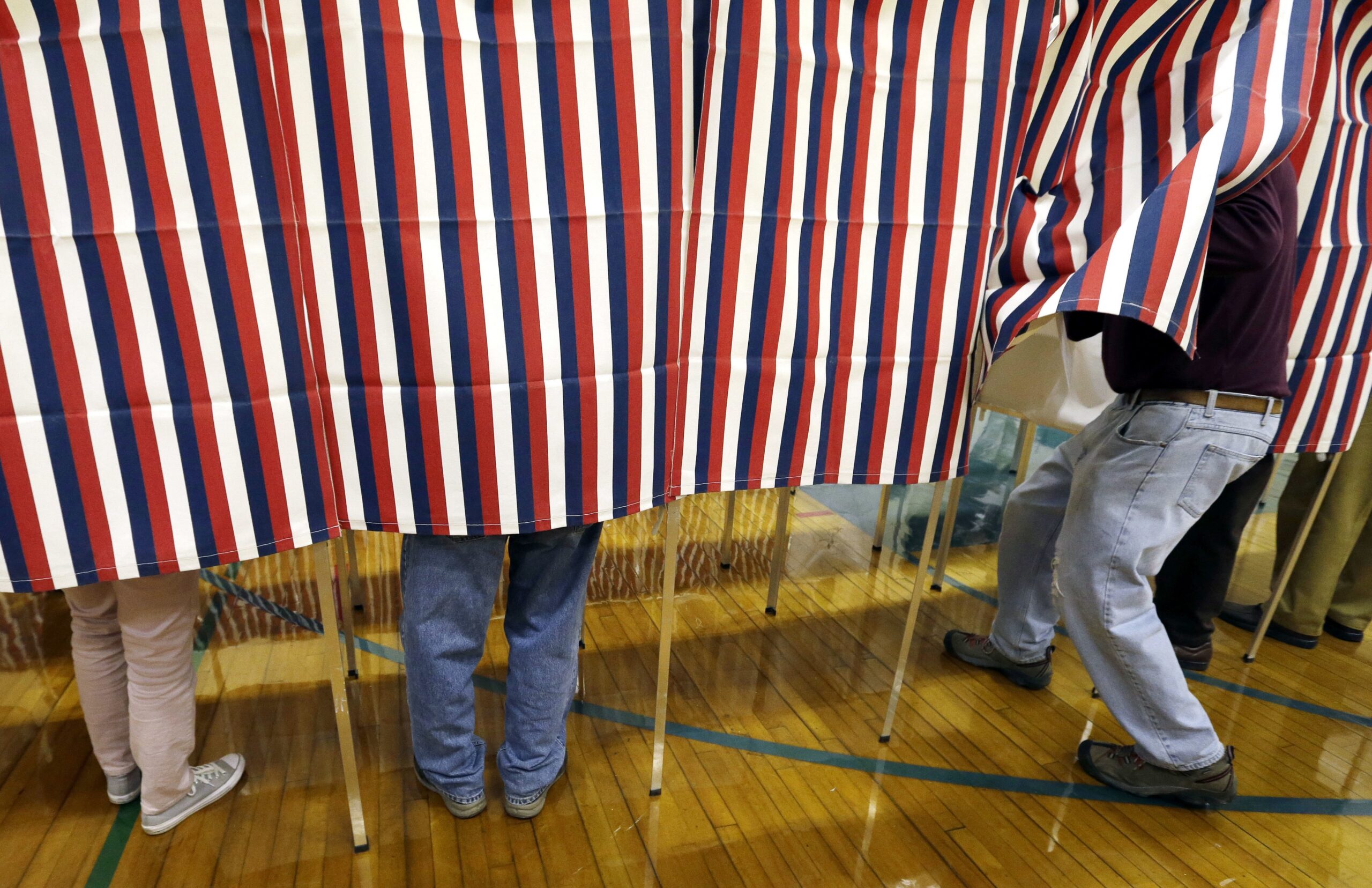People voting behind a curtain